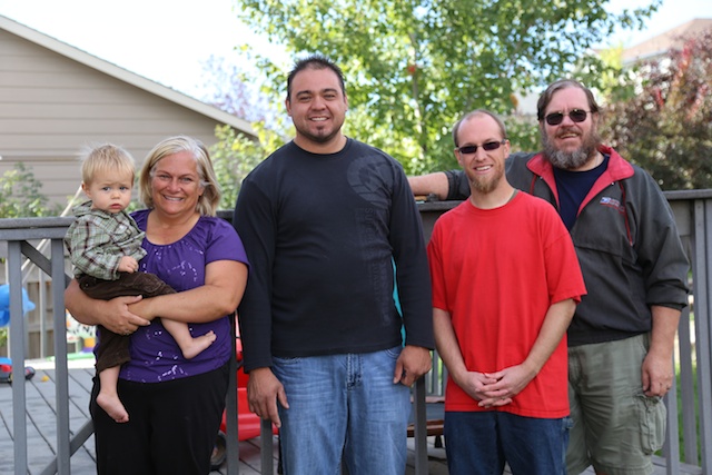 A team standing with single mom and baby